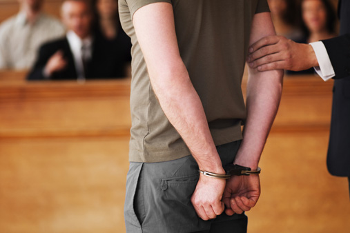 Handcuffed man standing in courtroom