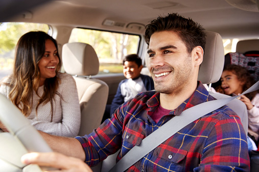 mom and dad in car with children