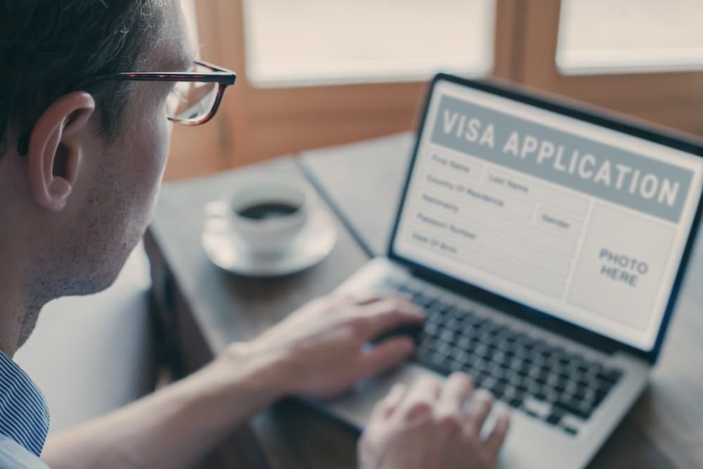 Online visa application, man filling form for immigration or work visa request for foreign country.
