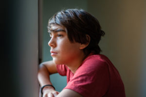 Boy looking through window