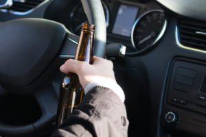 Man in car with open container