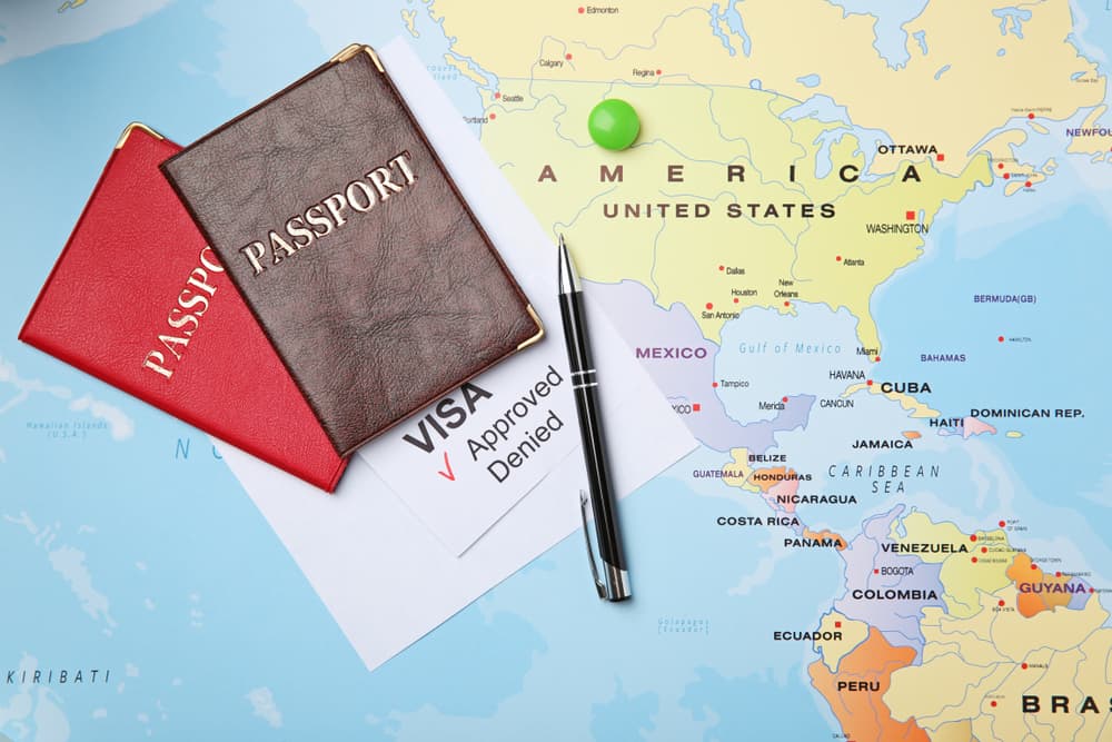 Passports and pen on map. Approved American visa