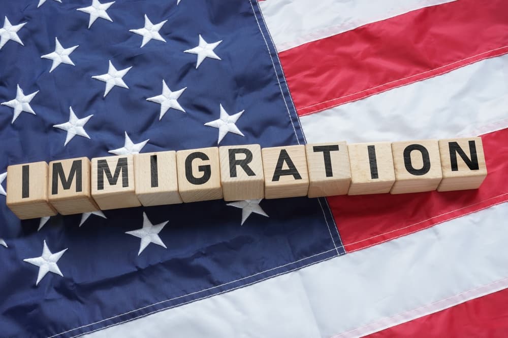 Immigration in USA is shown using a text on the flag of USA.