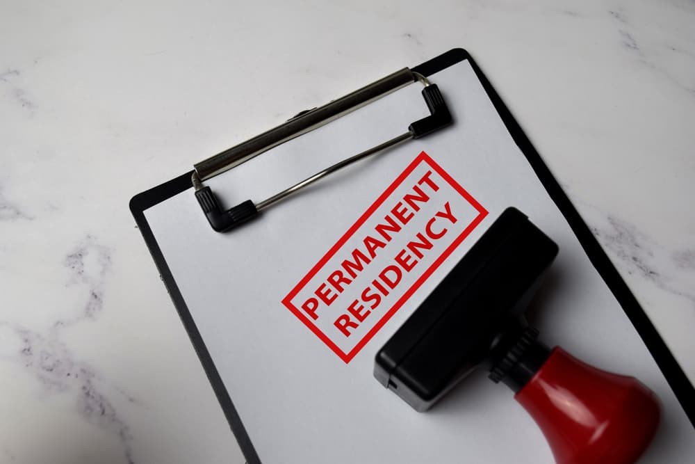 Red Handle Rubber Stamper and Permanent Residency text isolated on White Background