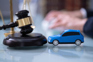 Lawyer discussing car insurance claim in courtroom with judge reviewing legal documents and legislation.