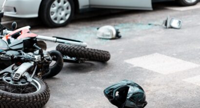 Overturned motorcycle and helmet on the street after collision with a car