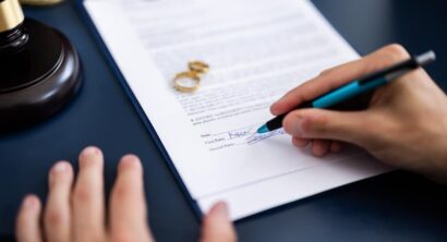 Young couple, one Caucasian and one Hispanic, consulting with a lawyer in court to sign a divorce agreement document.