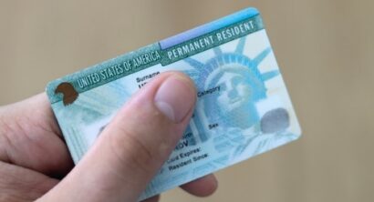 Close-up of a hand holding a United States permanent resident green card