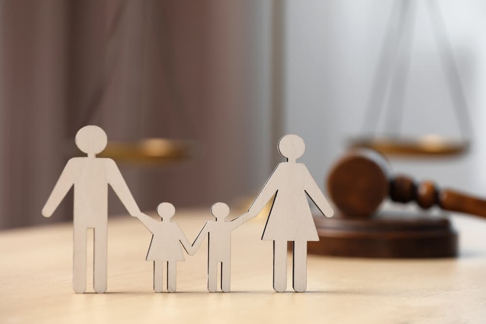 Figure of parents with children and gavel on wooden table