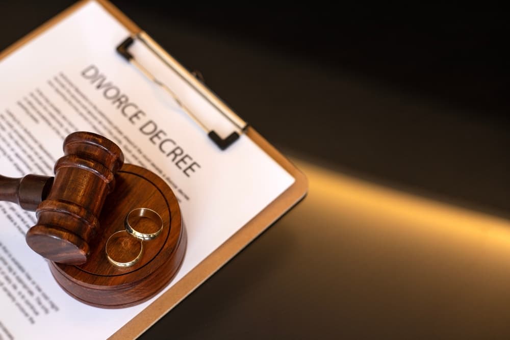 Divorce decree, gavel and wedding rings