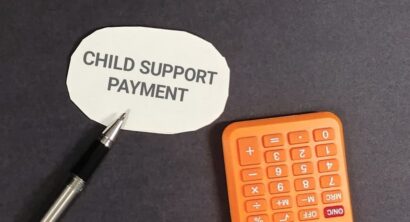Conceptual shot highlighting child support payment, featuring a calculator and pen,