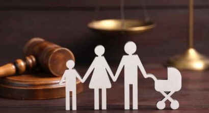 Family law. Figure of parents with children and gavel on wooden table