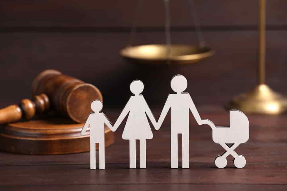 Family law. Figure of parents with children and gavel on wooden table
